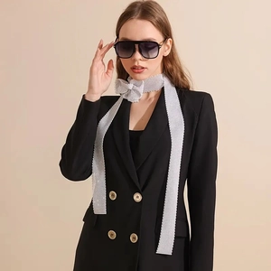 Écharpe élégante en strass argentés avec un nœud décoratif sur un blazer noir classique