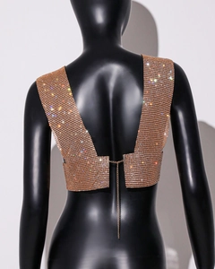 Detail eines goldenen Strass-Netz-Tops mit offenem Rücken und Metallkettenverschluss