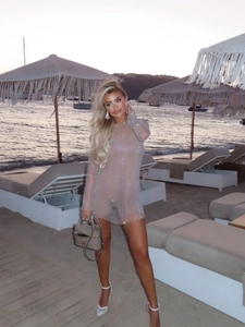 Sexy long sleeve sheer mesh mini dress with silver rhinestones on a beach setting