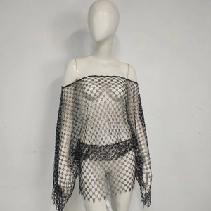 Close-up of black crochet lace dress with off-shoulder cut and floral fishnet patterns