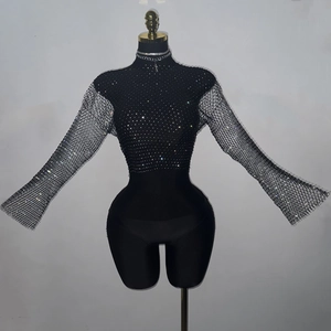 Detail view of sparkly rhinestones on black mesh top with flared sleeves and high neck
