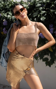 Detail of shimmering gold metal mesh two-piece set featuring sequin crop top and skirt
