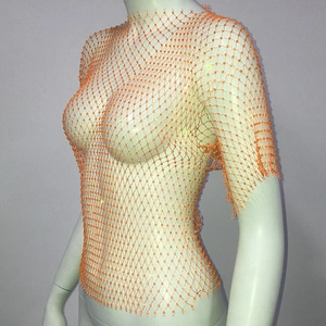 Close-up of orange mesh top with sparkling rhinestones for party wear on a mannequin