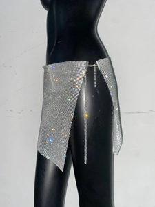 Détail d'une mini-jupe argentée en strass avec fente latérale et chaîne de taille ajustable