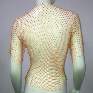 Detailed macro view of orange rhinestone mesh top with hand-woven diamond patterns