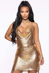 Détail d'une mini robe en maille dorée avec col bénitier et bretelles en strass