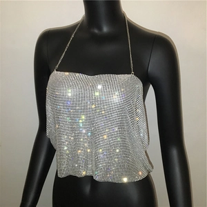 Détail macro du tissu en maille strass argentée et de la fine chaîne sur le haut sexy