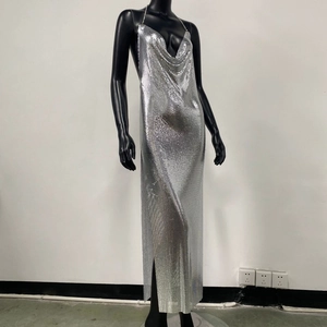 Dettaglio del vestito in rete metallica argento con scollo a cappuccio e spacco