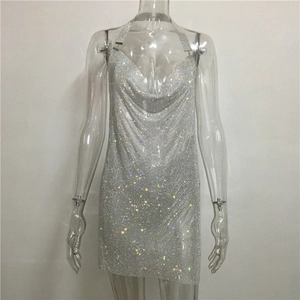 Détail d'une robe en maille strassée argentée avec décolleté bénitier et sequins brillants