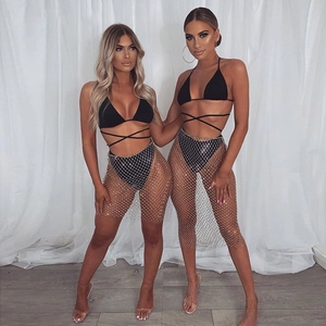 Detail of silver rhinestone fishnet mini skirt over black bikini for party wear