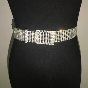 Détail de la ceinture en strass argentés avec plusieurs rangées de cristaux et boucle brillante