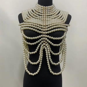 Détail macro du châle en perles blanches multicouches avec chaîne dorée élégante