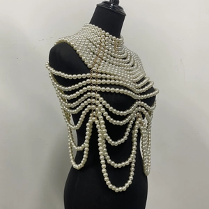 Détail d'une chaîne de corps multicouche en perles blanches avec pampilles dorées sur mannequin