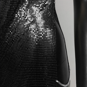 Detail of black metallic mesh sequin dress with silver side chains and high slit