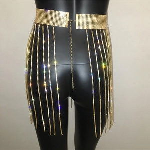 Detail of gold rhinestone body chain featuring long diamond tassels and a wide sequin belt