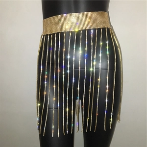Macro detail of sparkling gold rhinestone tassel chain and metal mesh waistband