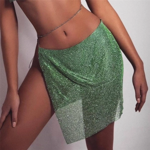 Mini-jupe étincelante en strass vert émeraude avec fente haute et chaîne de taille argentée