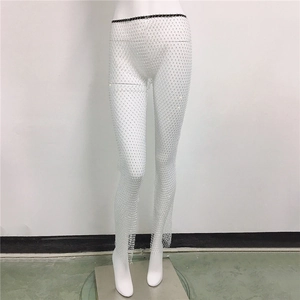 Vue détaillée du pantalon en résille blanche avec strass et détails de franges au bas