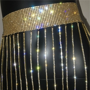 Detailed close-up of golden rhinestone fringe waist chain with shimmering tassel details