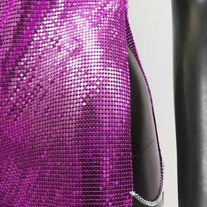 Detailed close-up of dark purple metal sequins and silver side chains on the dress