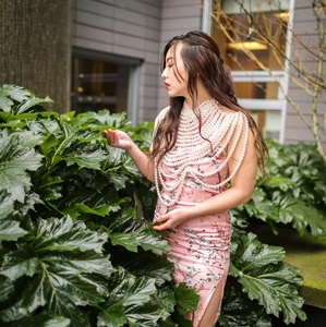 Élégante chaîne de corps multicouche en perles portée sur une robe à fleurs rose