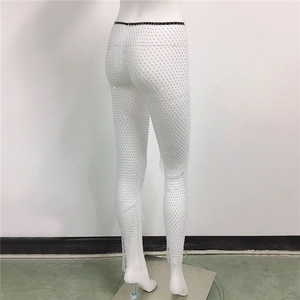 Détail du pantalon en résille blanche orné de strass brillants et maille élastique
