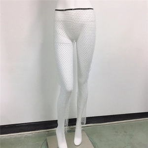 Détail de pantalon en résille blanche avec strass brillants et texture filet élastique