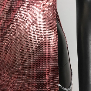Detail of rose gold metal sequins and side slit chain on a party dress close-up