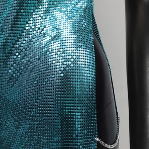 Detail of teal metal sequins and silver chain trim on a sexy high-slit party dress