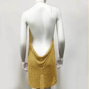 Detail of gold metal mesh sequin dress featuring an open back and halter neck design