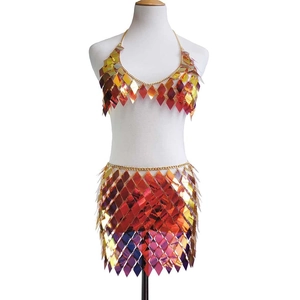 Close-up of holographic rhombus sequins and gold metal chain links on a two-piece dress set