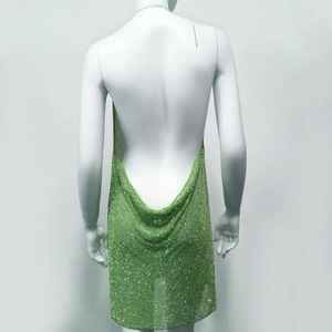 Close-up of vibrant green rhinestone mesh fabric and open back detail on the dress