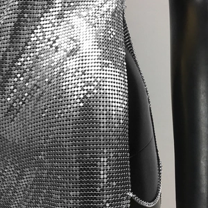 Macro detail of silver sequin chainmail dress with metal chain link side closure