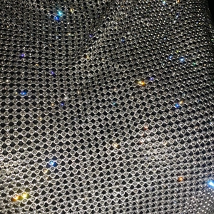 Gros plan de strass étincelants sur maille noire avec des reflets colorés éclatants