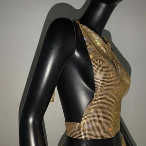 Détail du haut en maille dorée avec strass montrant la texture et la finition brillante