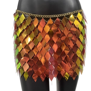 Detailed view of layered orange diamond-shaped sequins on a gold chain mini skirt
