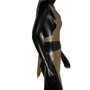 Détail de haut licou en résille strassée dorée et mini-jupe avec fente sur mannequin