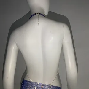 Dettaglio del top all'americana blu scuro con strass, catene in metallo e paillettes lucide