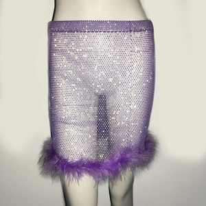 Détail de la jupe en résille violette avec strass denses et bordure en plumes luxe