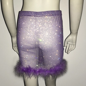 Détail jupe en mesh violette avec strass brillants et bordure en plumes douces au bas