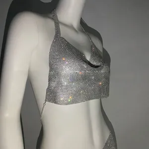 Dettaglio del top all'americana in maglia argento con strass densi e scollo a V profondo