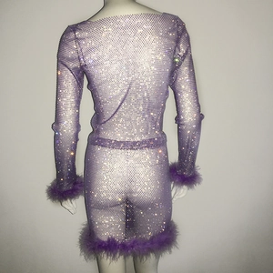 Detail eines lila Netzkostüms mit Strasssteinen und Straußenfedern an den Bündchen