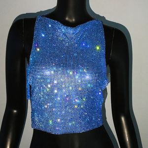 Détail d'un haut bleu en strass avec mailles métalliques étincelantes et détails en cristaux