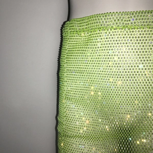 Détail macro d'une jupe en maille vert fluo avec strass étincelants pour soirée