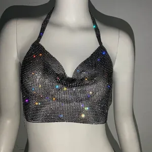 Dettaglio di strass luccicanti e scollo a capestro su un top corto nero da festa