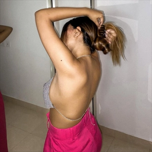 Detalle del top corto sexy de pedrería con espalda descubierta y cadenas plateadas