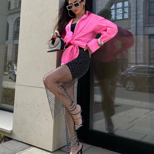 Dettaglio dei pantaloni a rete con strass e della gonna decorata per un look street style audace