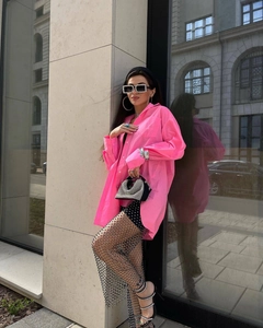 Dettaglio camicia rosa oversize con gonna a rete di strass e borsa da festa scintillante