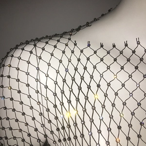 Détail de la chaîne de corps en maille noire avec cristaux brillants sur le tissu