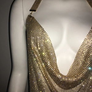 Détail de la robe en maille métallique dorée avec strass et décolleté en V plongeant